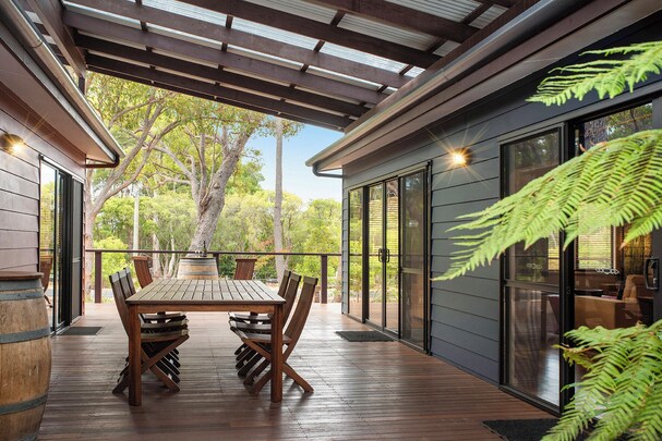 Brumby Cottage kitchen with white cabinets, timber beams, fridge, microwave, oven and gas cooktop, window to verandah, Margaret River