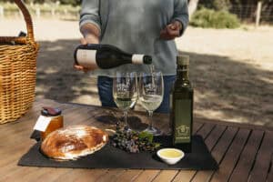 Close-up of a Margaret River wine tasting, with a bottle and five glasses of chilled white wine lined up on the counter.