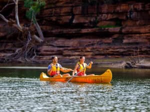 Couple paddling a canoe on the calm waters of the Murchison River in Kalbarri National Park.