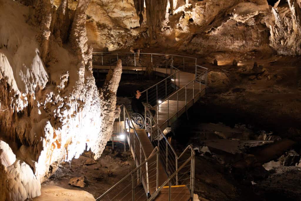 A visitor on a wheelchair-accessible boardwalk inside Mammoth Cave, surrounded by ancient limestone stalactites and stalagmites during a 3-day Margaret River escape.